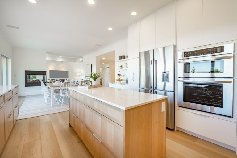 Daylight,Kitchen,Interior,With,Long,White,Countertop,Wooden,Cabinets,Stainless