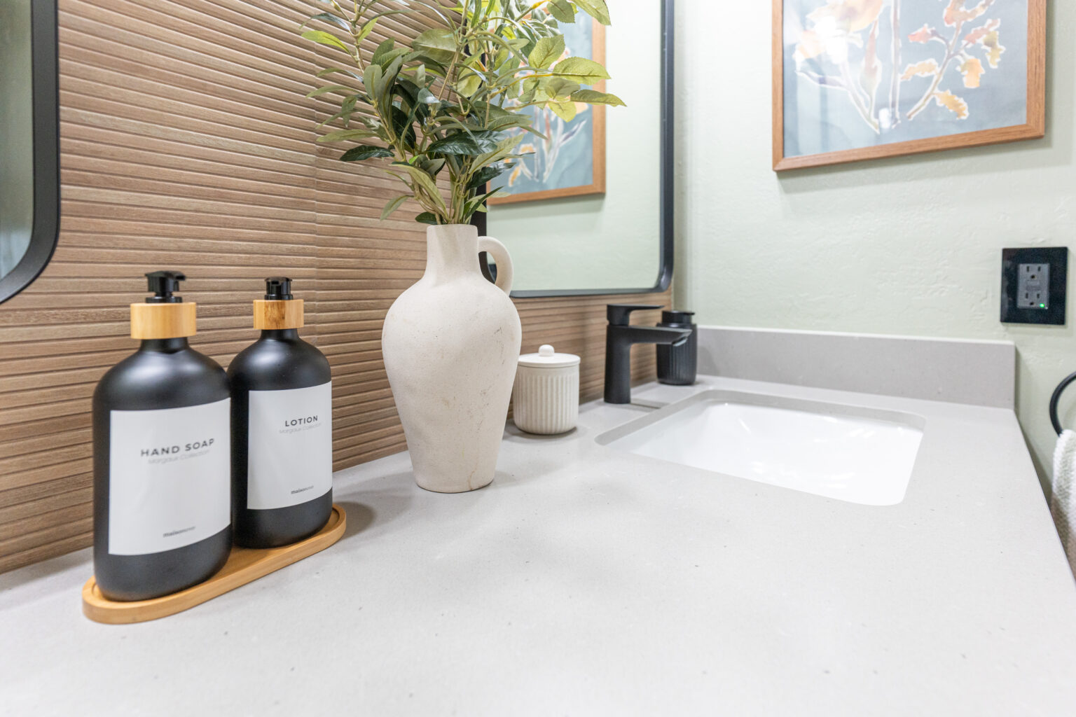 Contemporary bathroom remodel in San Diego featuring a frameless glass shower with geometric tile flooring, textured wood wall accents, and a modern toilet – designed by expert San Diego bathroom remodeling contractors, Lusso Design and Build.